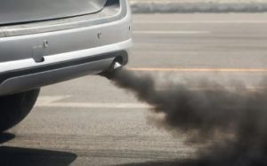 Mechanic repairing a car exhaust system on a hoist
