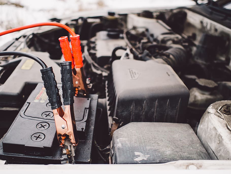 jumper-cables-battery-engine-car Jumper cables connected to a car battery