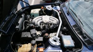 Car engine bay under inspection by a mechanic