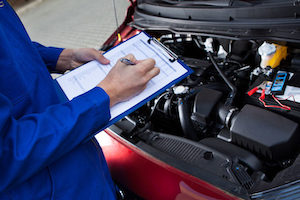 Mechanic performing engine diagnostic check for car performance.