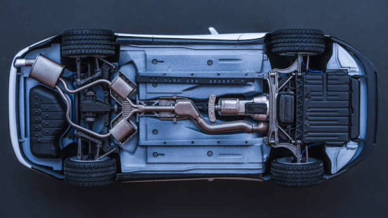 inverted car on a black background. bottom view of car Underside of a car showing the exhaust and chassis