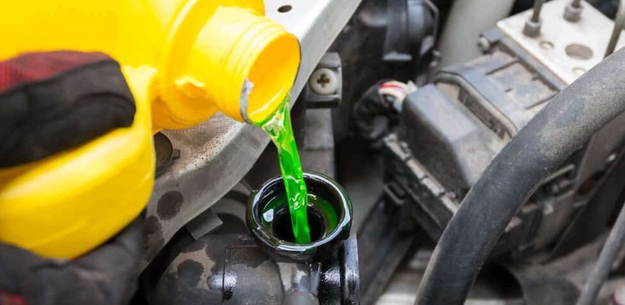 Pouring green coolant into a vehicle's cooling system