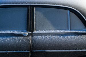 Frost covering a black car on a cold winter morning