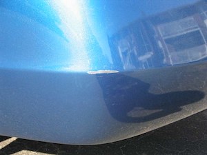 Close-up of paint scratch on a car body panel