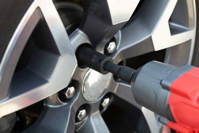 Precision torque wrench securing a car wheel lug nut.