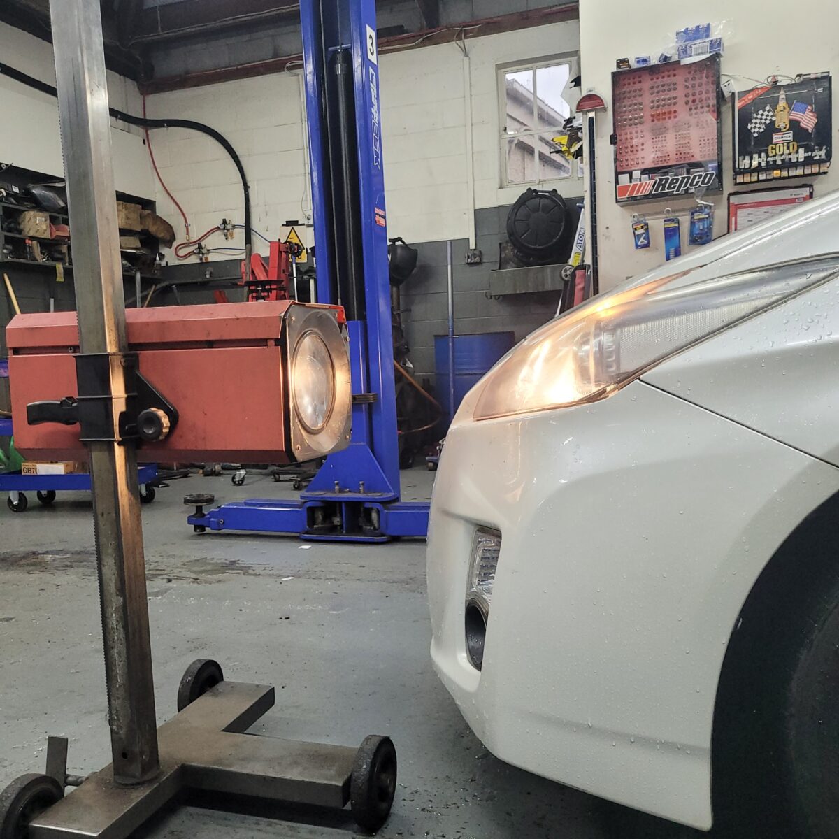 file-1752207402450-50840790 Illuminated headlight on a white Toyota Prius in the workshop
