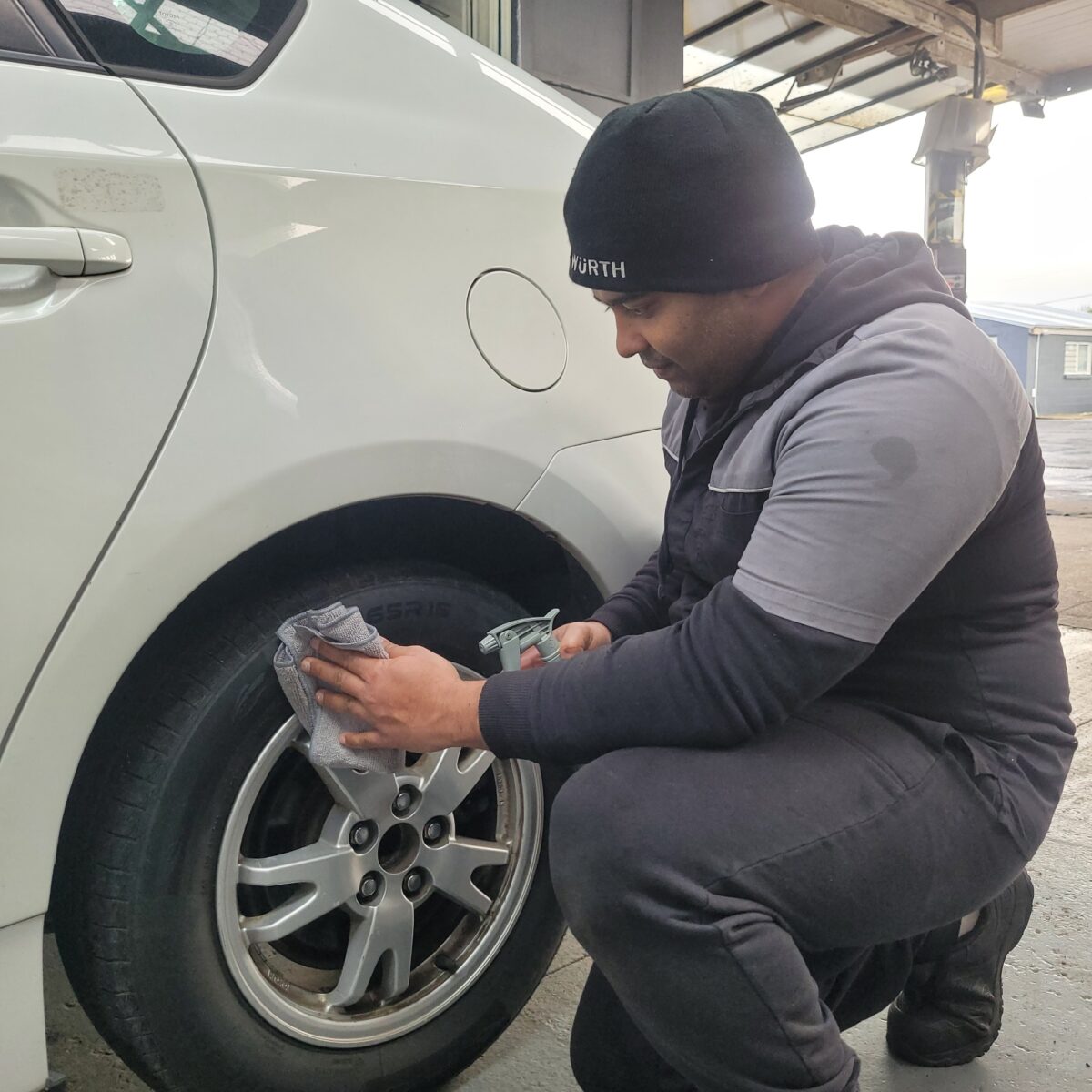 file-1752467412887-122685455 Mechanic spraying and wiping a car alloy wheel and tyre