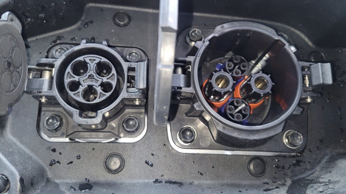 Close-up of an electric vehicle charging port with multiple connectors.