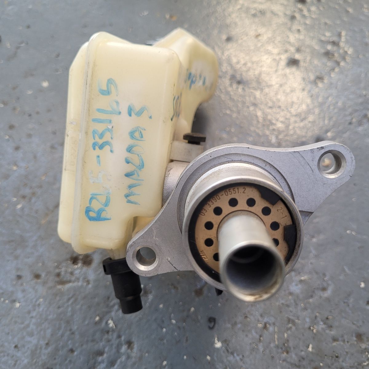 Front view of a Mazda 3 brake master pump on a garage floor