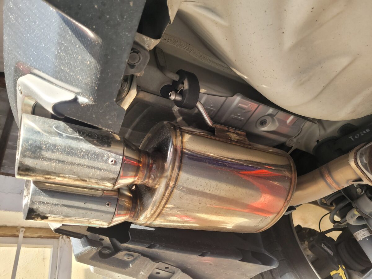 View from underneath a car, showing a chrome exhaust and muffler. View from underneath a car, showing a chrome exhaust and muffler.