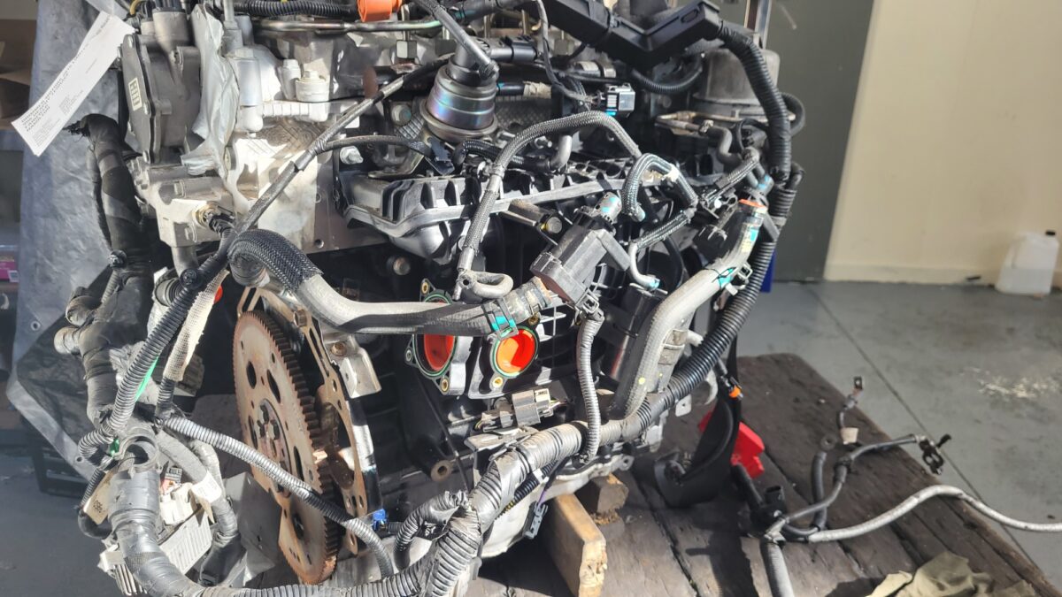 A detailed view of a complex car engine, with various wires and components.