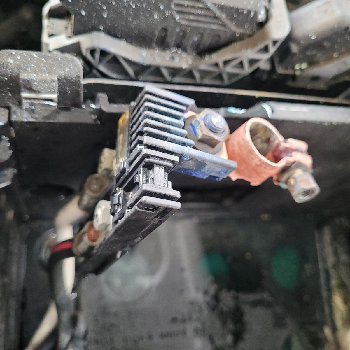 Close-Up of a Corroded Battery Terminal Connection Corroded car battery terminal with attached wiring and connector.
