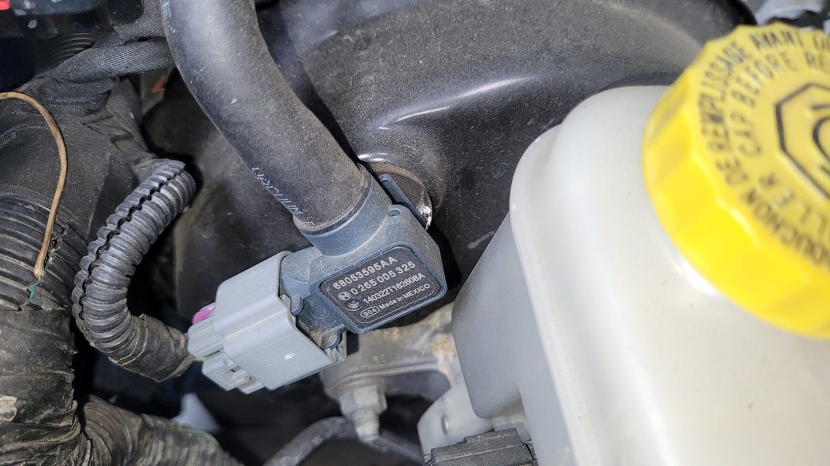 Brake Booster Vacuum Sensor in Engine Bay Close-up of a brake booster vacuum sensor connected to a vacuum line.
