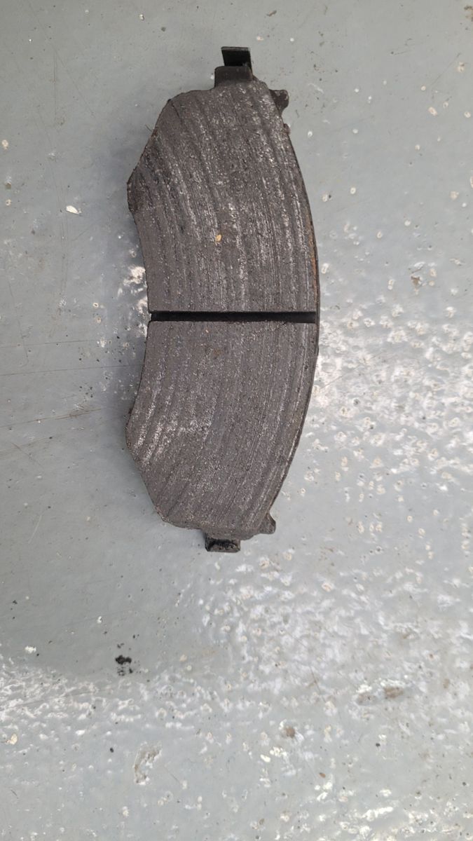 Single used brake pad with visible grooves and wear
