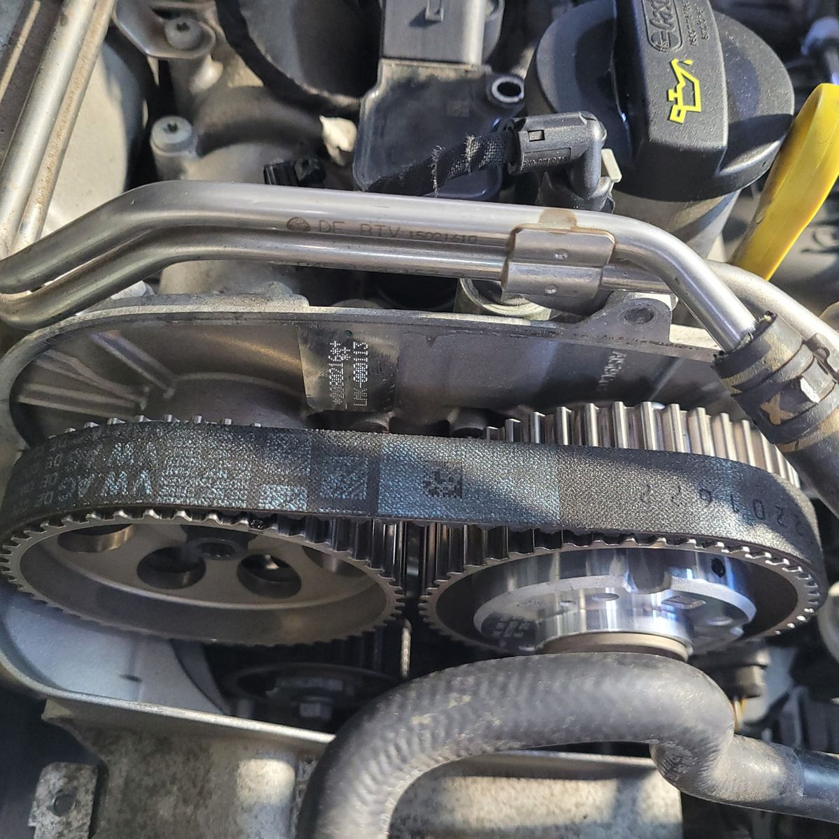 Close-up View of a Car Cambelt Installation Black cambelt fitted over engine pulleys in a car engine bay