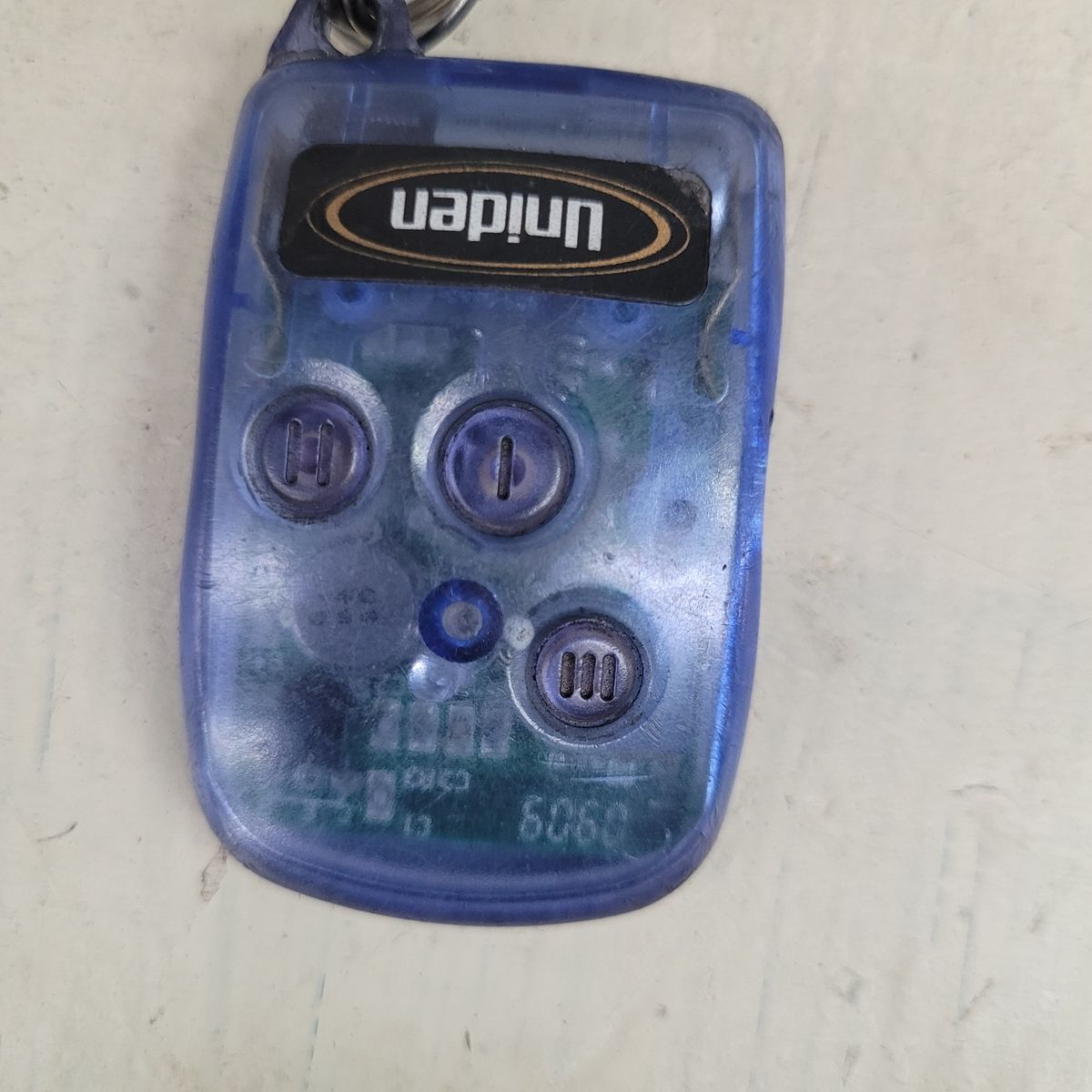 Transparent blue car alarm remote with three buttons and a keyring