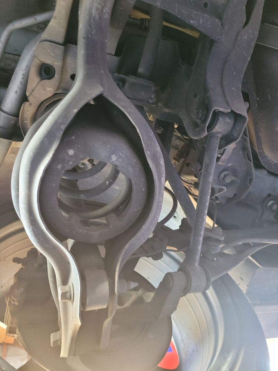 Automotive Control Arm and Suspension System Detail Close-up of a vehicle control arm with attached suspension components