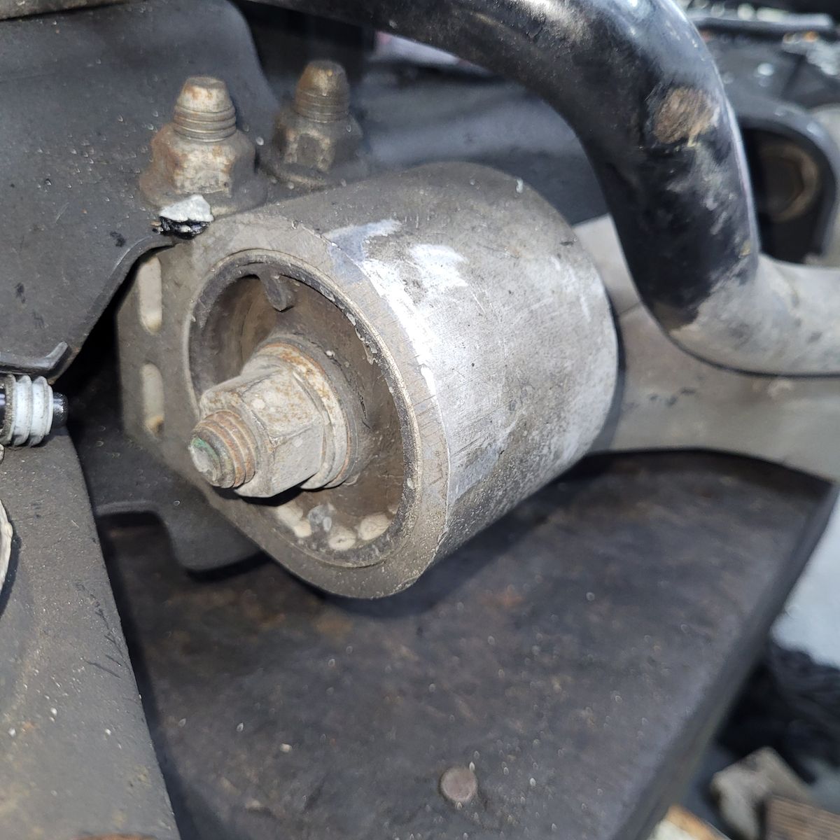 Close-up of Car Control Arm Bush Worn automotive control arm bush attached to a metal suspension assembly