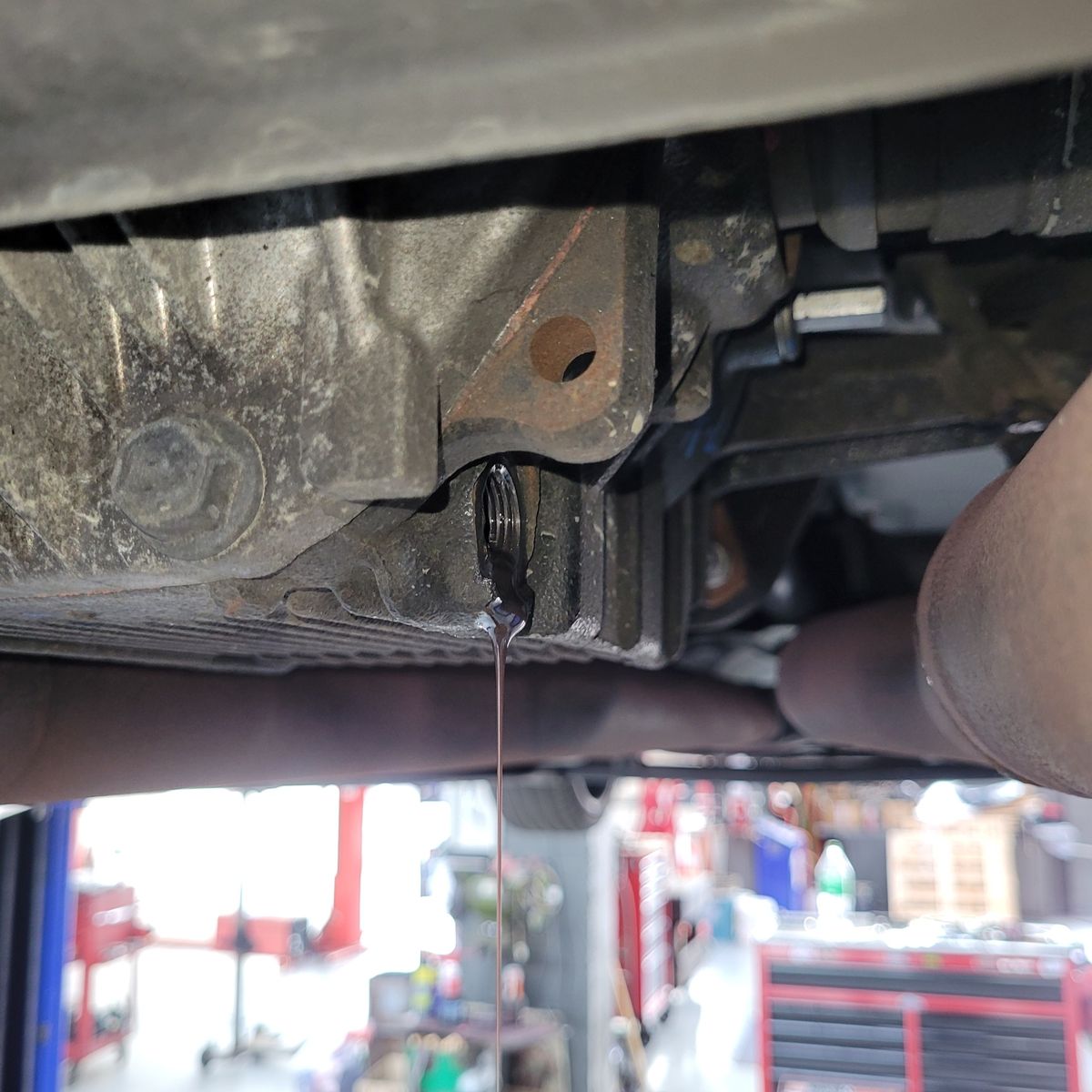 Dark differential fluid draining from a vehicle in a garage