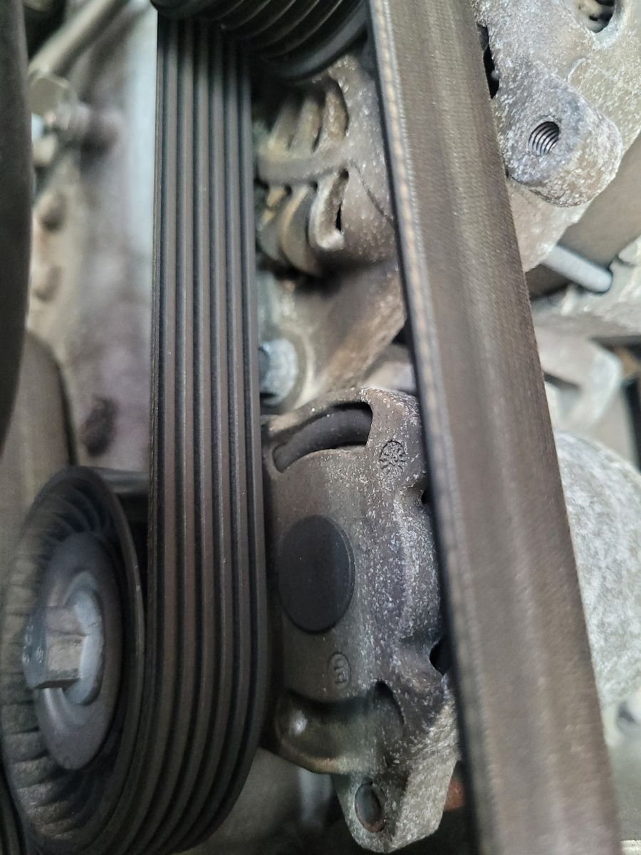 Detailed shot of a car's serpentine drive belt and pulley system