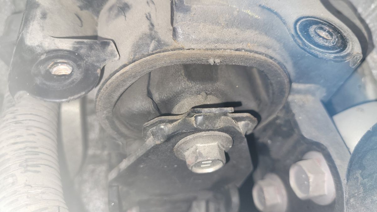 Close-up of a Car Engine Mount Dusty car engine mount with visible bolt and rubber bushing