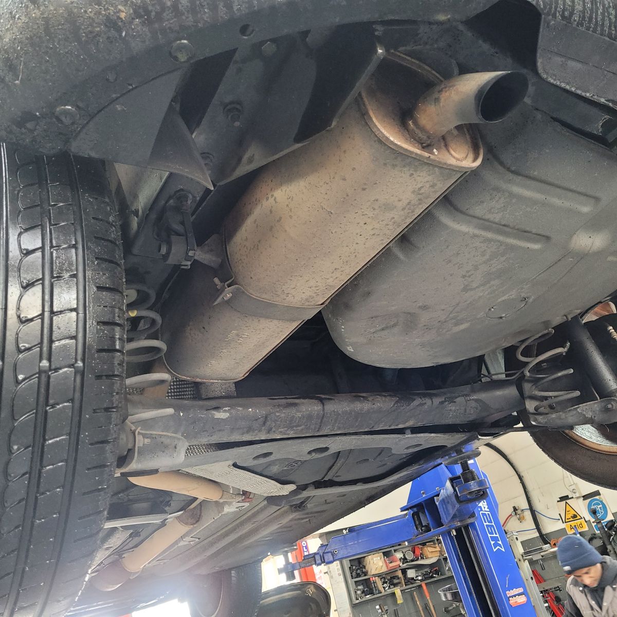 View of car exhaust system and undercarriage on a mechanic's lift