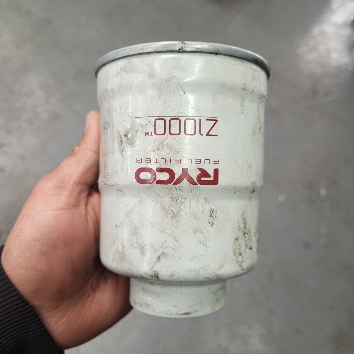 Hand Holding Used Diesel Fuel Filter Person holding a dirty RYCO diesel fuel filter