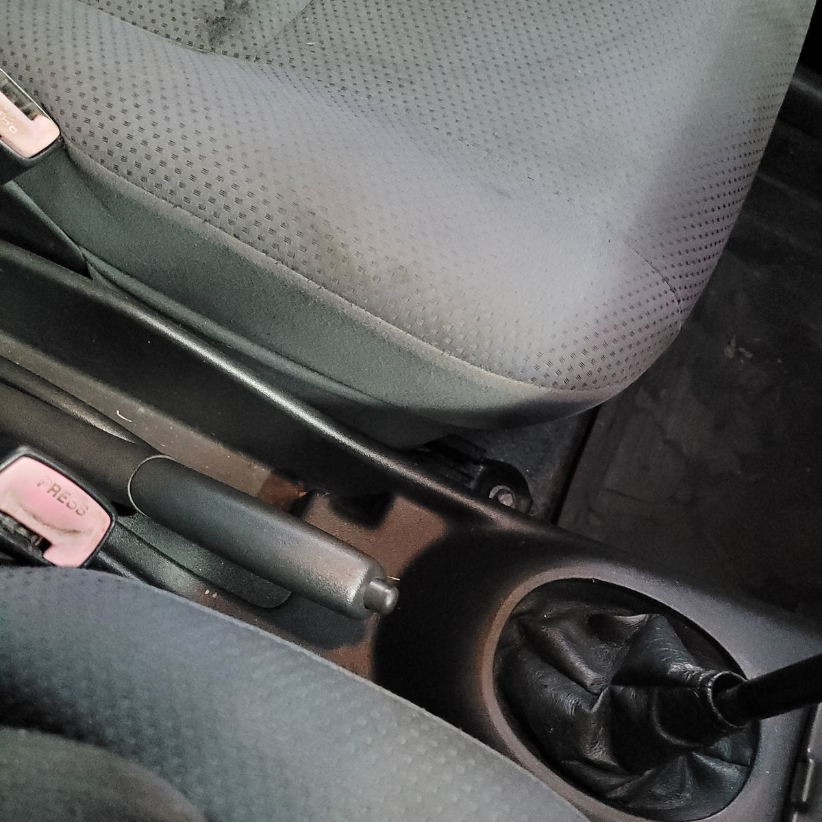 Handbrake in Down Position Car handbrake lever fully lowered beside gear stick and seat