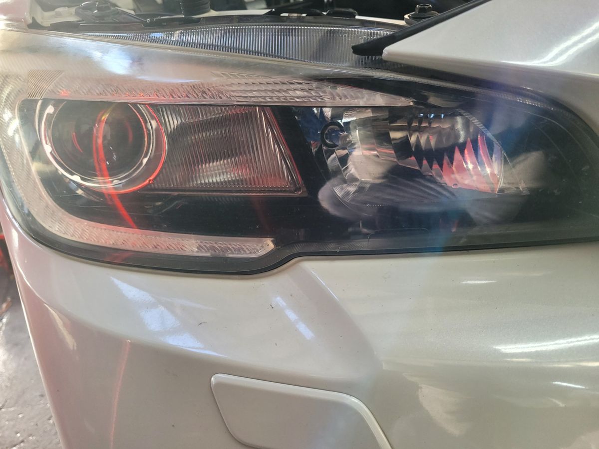 Detailed view of a modern car headlight on a white car