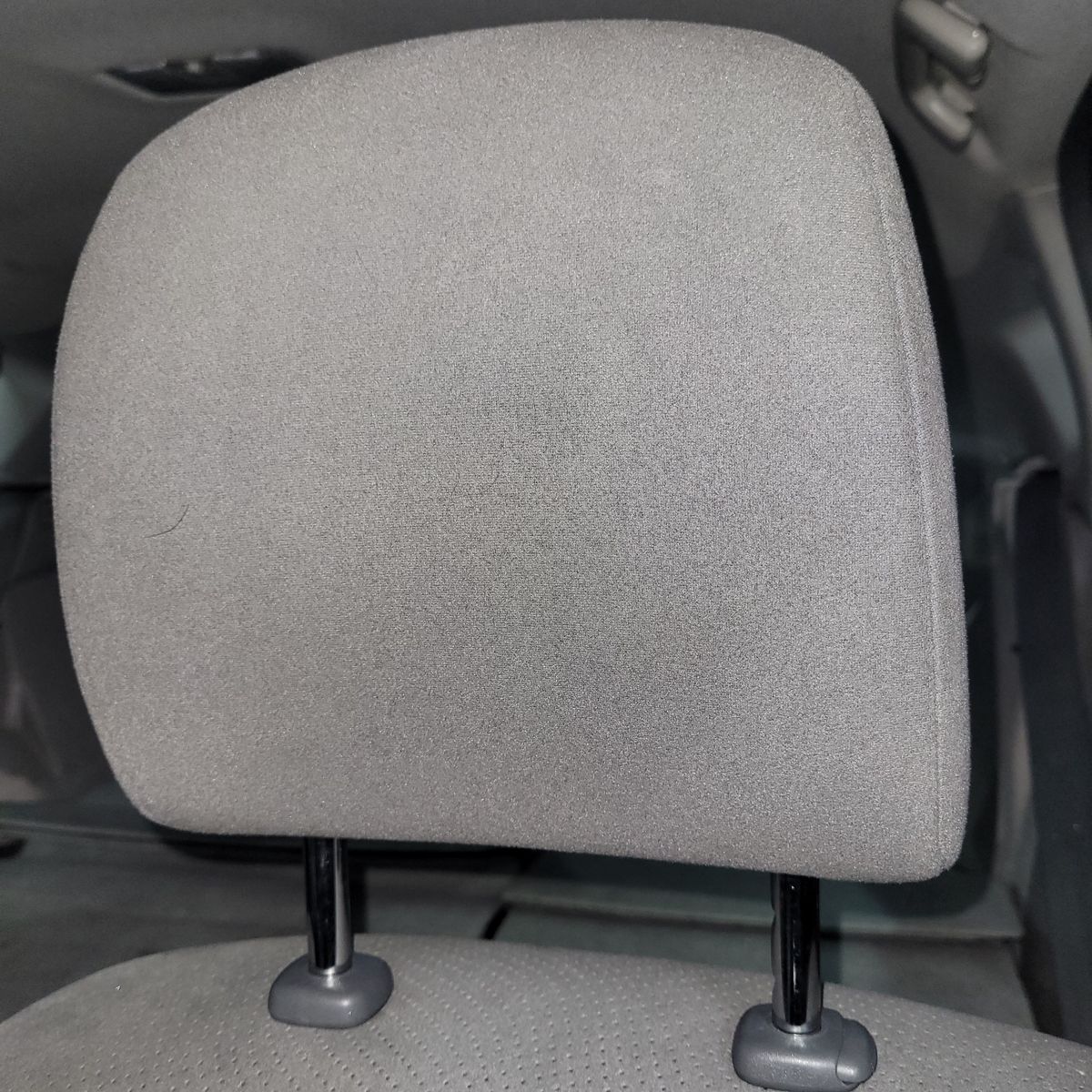 Gray fabric car headrest with adjustable posts in vehicle interior