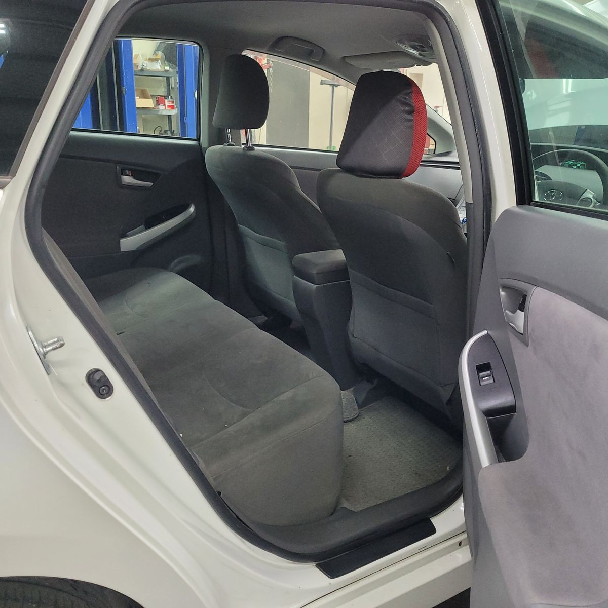 Open rear door showing the backseat of a hybrid car
