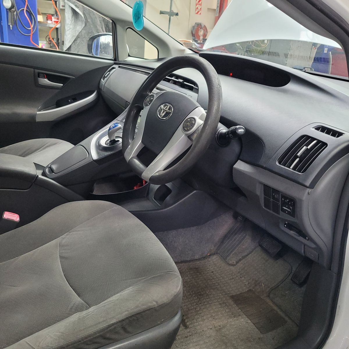 Driver's view of a Toyota hybrid car interior, dashboard and seats visible.