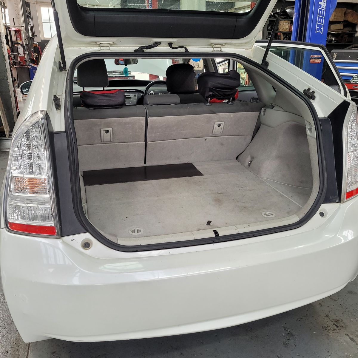 Open Trunk of a White Hybrid Car View of spacious, open trunk in a white hybrid car, rear seats visible.
