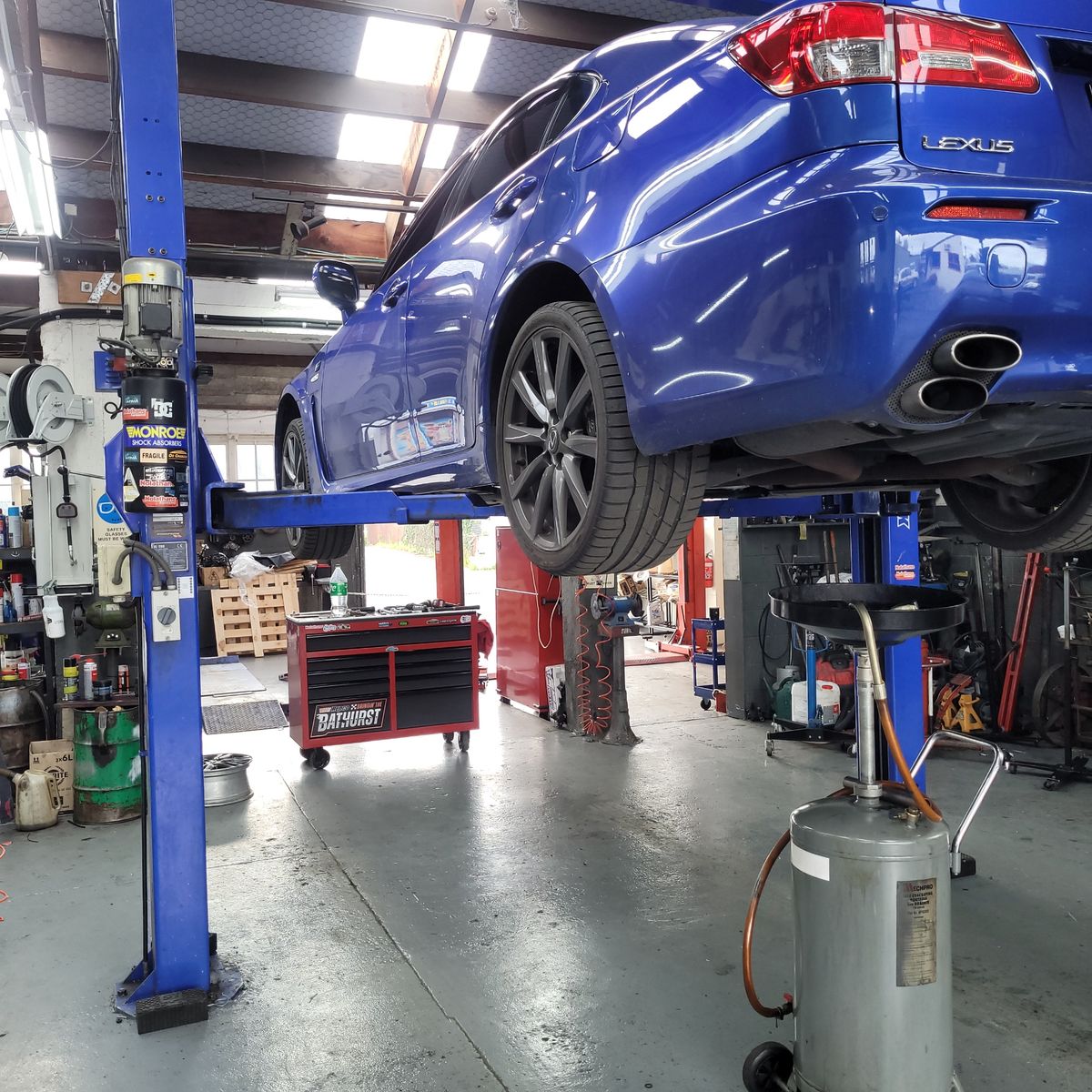 Lexus on Hydraulic Lift in Service Garage Blue Lexus sedan elevated on a hydraulic lift in an auto repair shop.