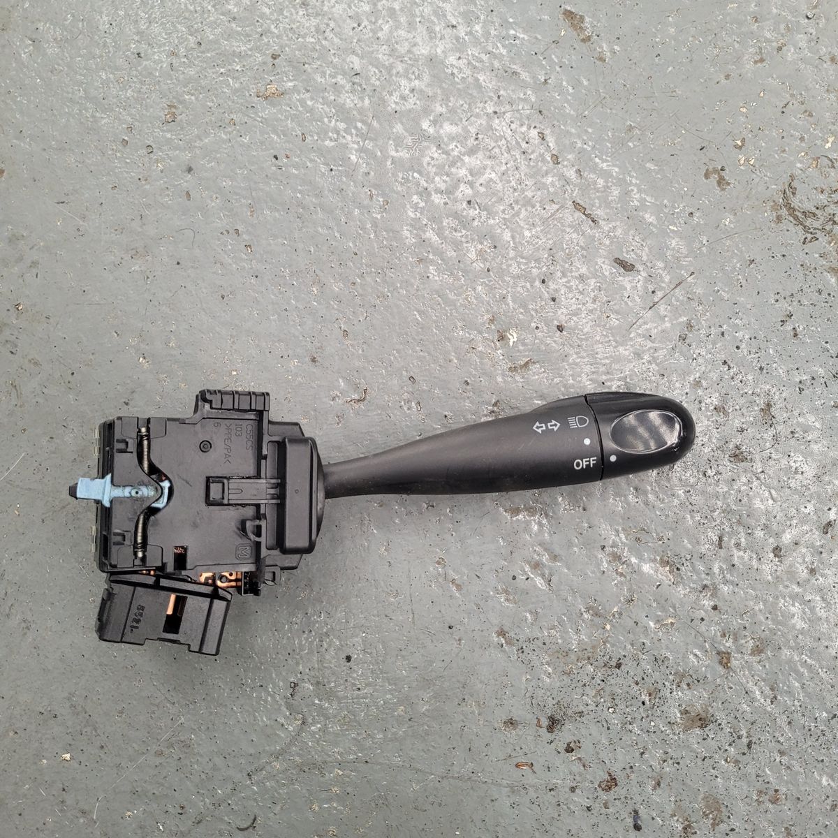 Car Indicator and Headlight Switch Lever Black car headlight and turn signal switch lever on gray surface