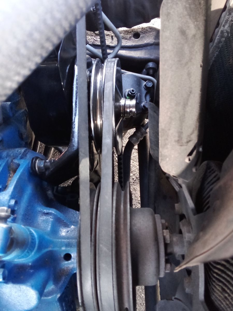 Close-Up View of Power Steering Belt in Engine Bay Power steering belt wrapped around pulleys in a car engine compartment