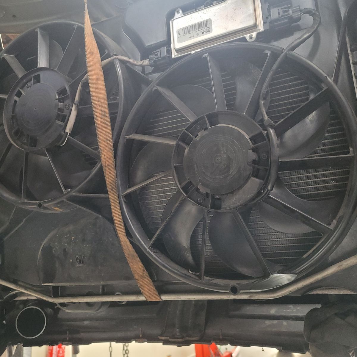 Two black radiator cooling fans mounted under a vehicle hood.