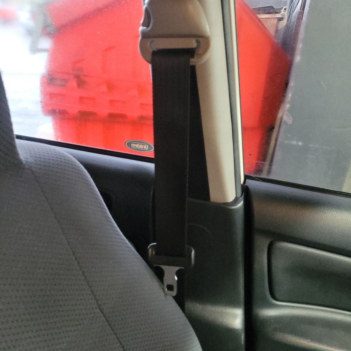Car Seatbelt by Passenger Seat and Window Close-up of a seatbelt next to a car seat and window