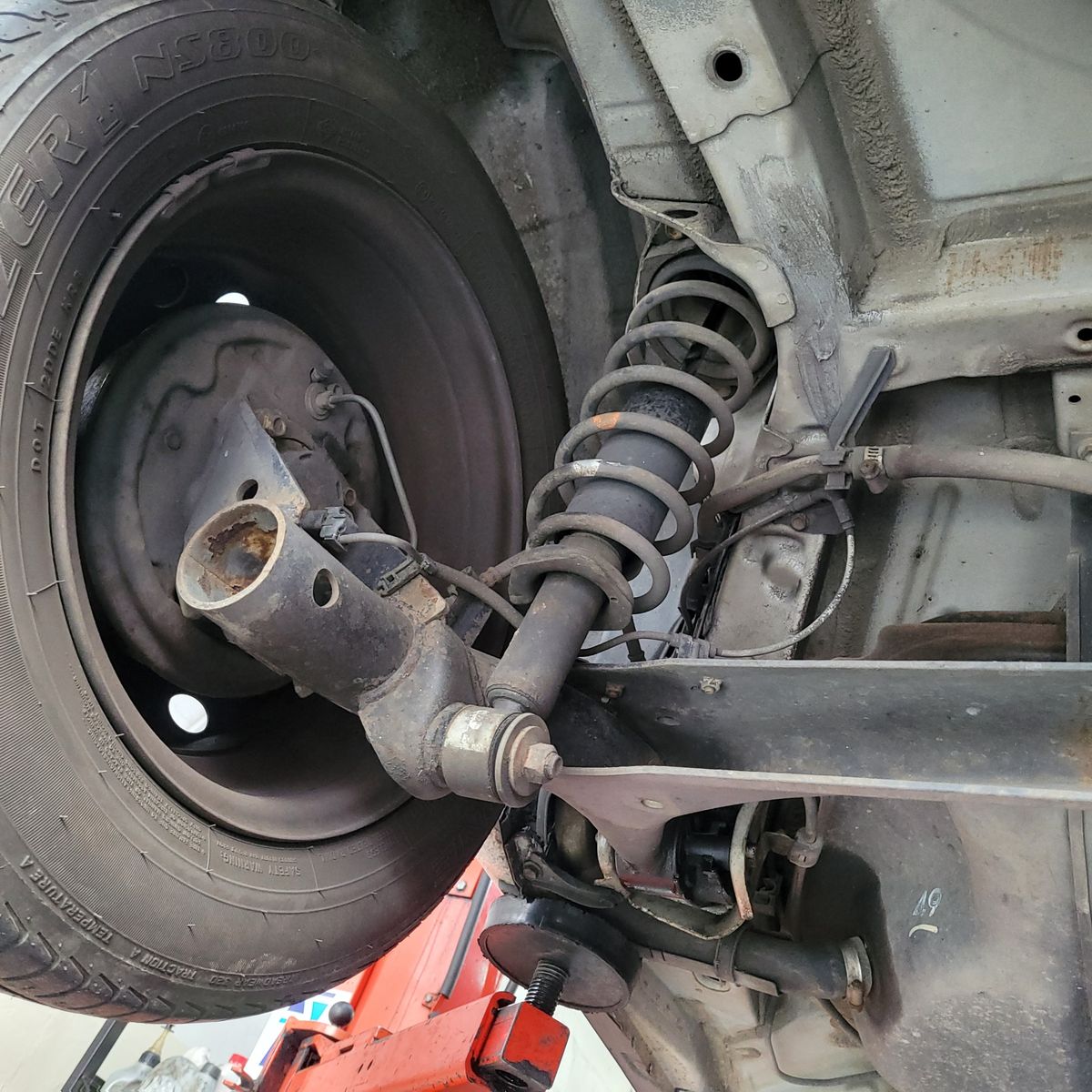 Close-up of Car Suspension and Wheel Assembly Detailed view of a car's rear suspension system and coil spring.