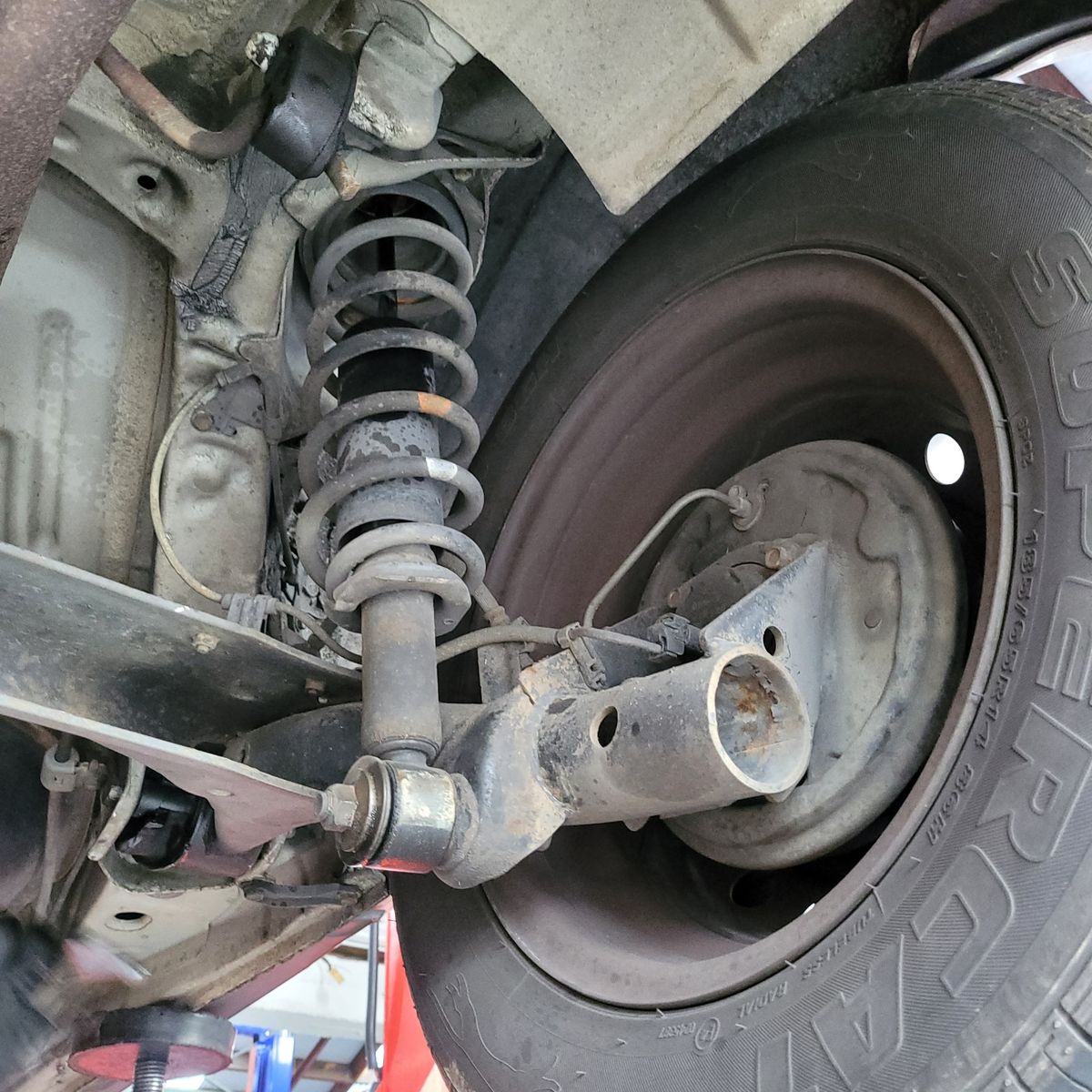 Car suspension system, coil spring, and attached wheel up close