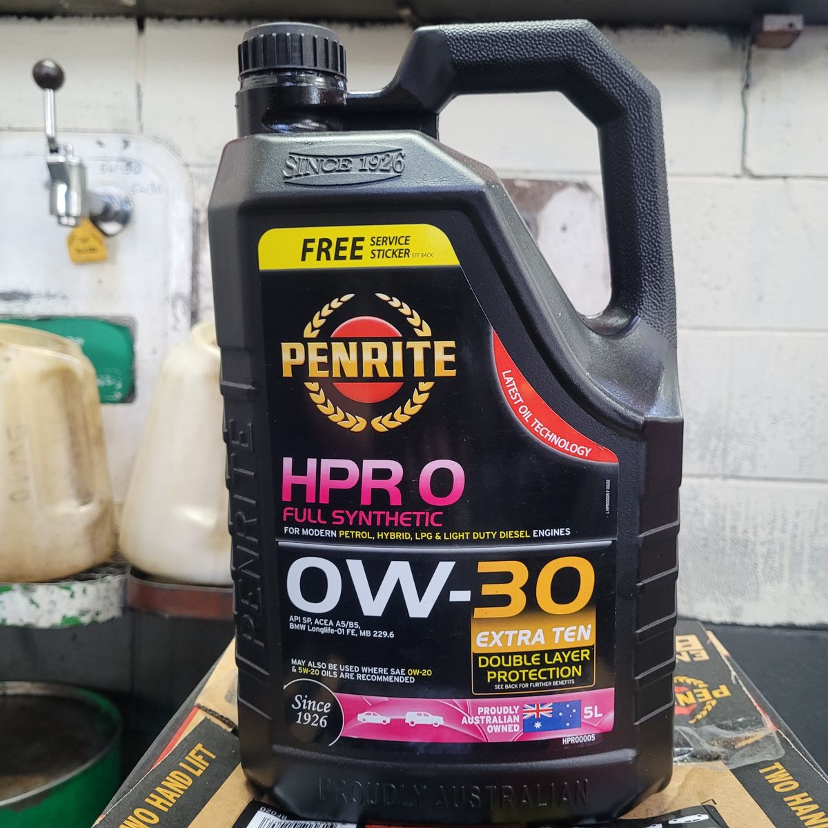 Penrite Full Synthetic 0W-30 Motor Oil Container Black Penrite HPR 0 full synthetic 0W-30 motor oil container on a workshop bench.