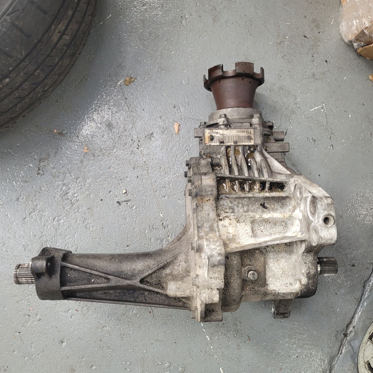 A transfer case for a vehicle lying on a concrete garage floor