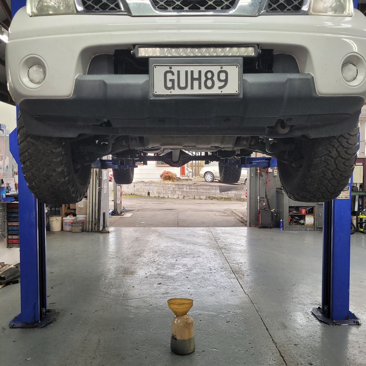 Vehicle on Lift for Tyre Alignment SUV raised on hydraulic lift in workshop, tyre alignment in progress