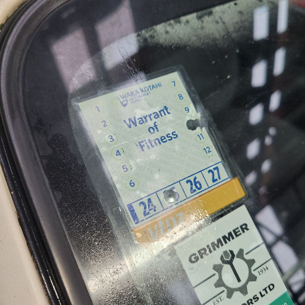 New Zealand Warrant of Fitness Sticker on Car Windscreen Close-up of a New Zealand Warrant of Fitness sticker displayed inside a car windshield.