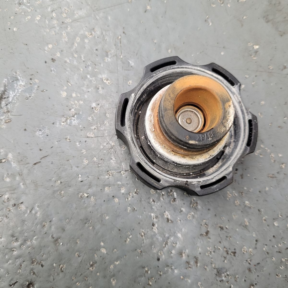 A car radiator cap showing significant rust and corrosion.